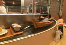 Water kaiten conveyor, sushi floats on boats from a kitchen to the client’s table