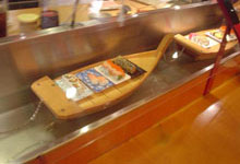 Water kaiten conveyor, sushi floats on boats from a kitchen to the client’s table